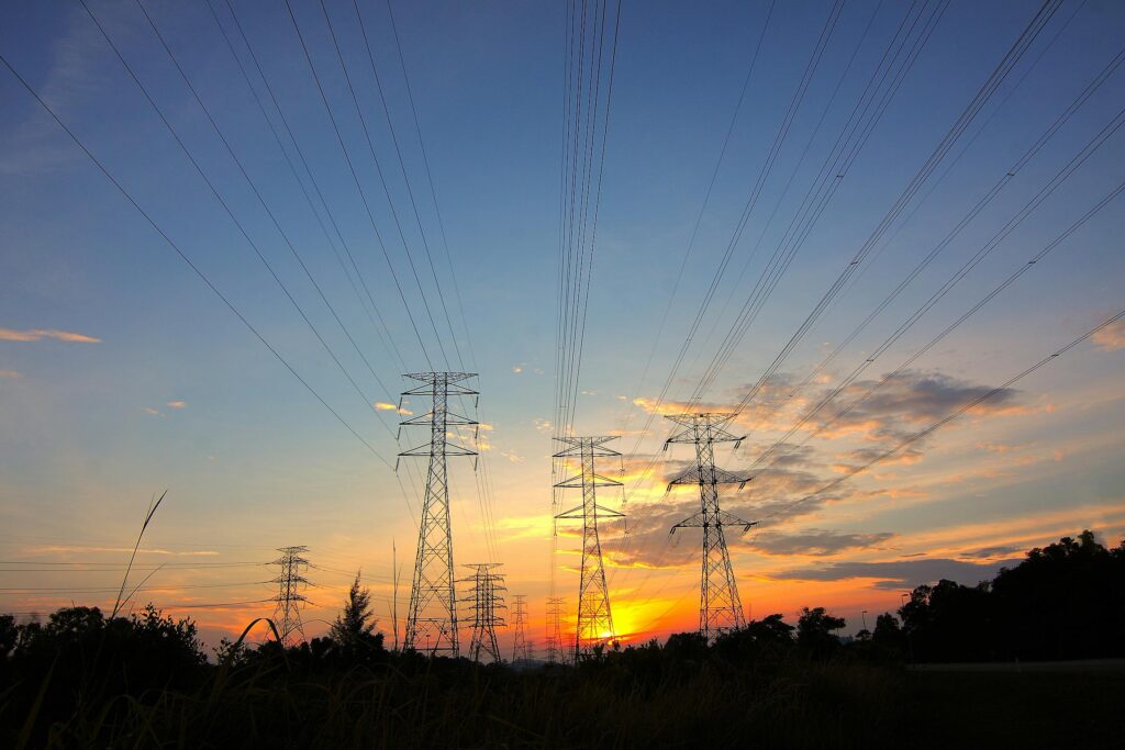 pexels-photo-171428-171428 Silhouette of power lines against a dramatic sunset sky in a rural landscape.